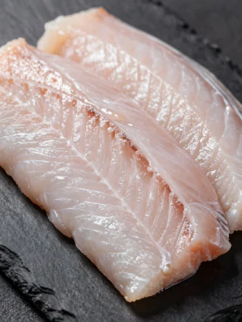 Čerstvé filety z úhoře s kořením na dřevěném prkénku