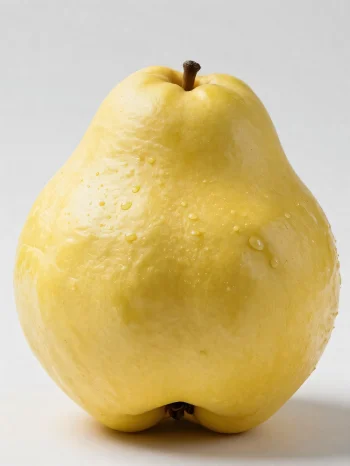 Celé a nakrájené plody kdoule na dřevěném povrchu, se zelenými listy