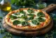 Servírovaná špenátová pizza Quattro Formaggi s roztaveným sýrem