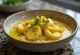 Moqueca servírovaná s mangem, rybami a kokosovým mlékem