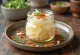 Daikon-zuke, plátky čerstvé ředkve v octovém nálevu podávané na bílém talíři, zdobené koriandrem