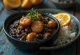 Feijoada servírovaná s rýží a plátky pomeranče