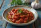 Ajvar s olivovým olejem, zdobený čerstvými bylinkami