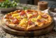 Havajská pizza s uzenou šunkou servírovaná na dřevěném prkénku